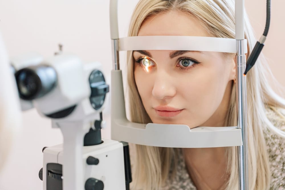 Comprehensive Eye Health Evaluation with Advanced Diagnostic Equipment – Houston Eye Exam Close-up of a woman undergoing a detailed eye examination using advanced diagnostic equipment at an optometry clinic – Houston Eye Exam